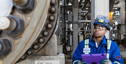 Male engineer inspecting heavy machinery in oil facility