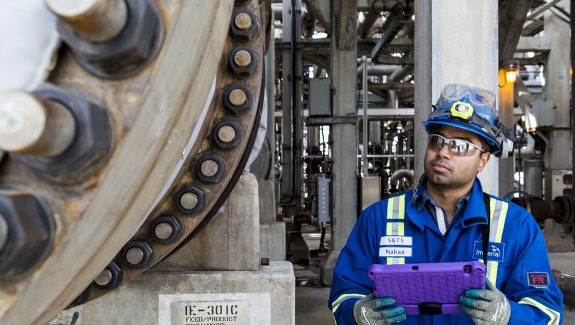 Male engineer inspecting heavy machinery in oil facility