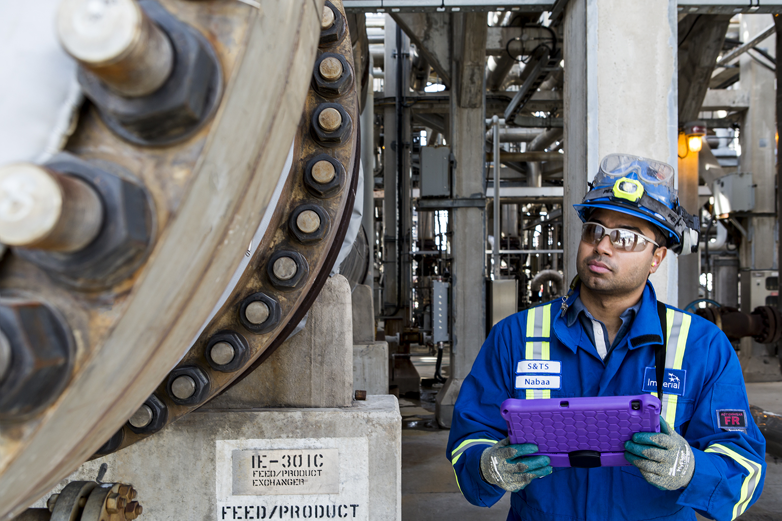 Male engineer inspecting heavy machinery in oil facility