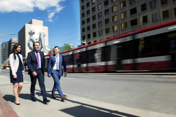 Downtown Toronto with 3 business people walking down the street